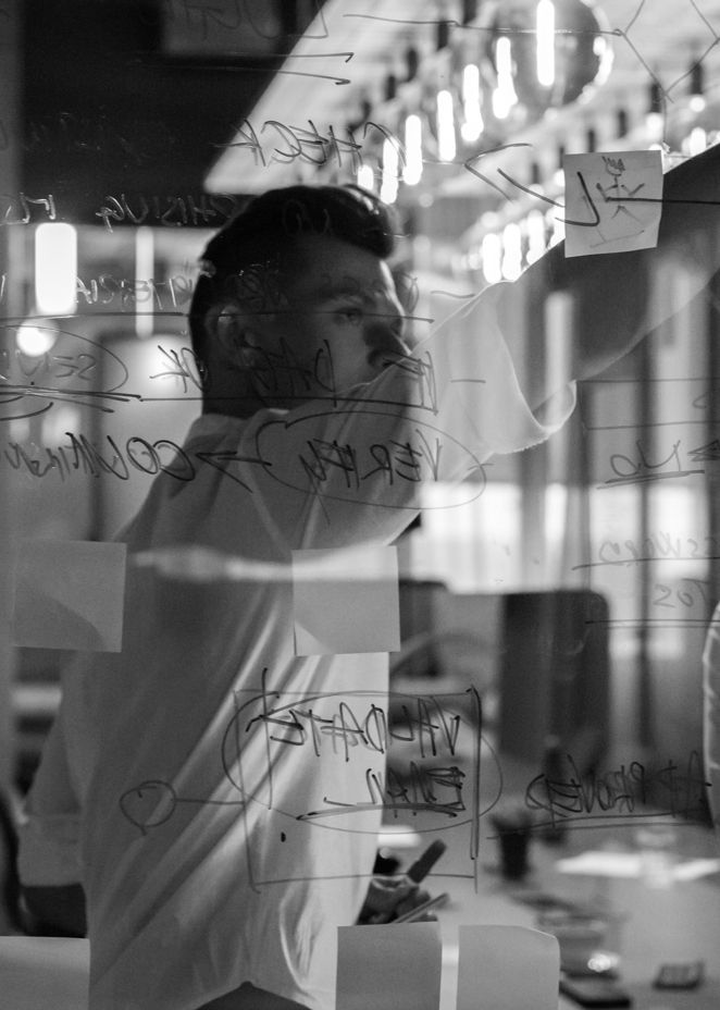 Man writting on the glass scrum board